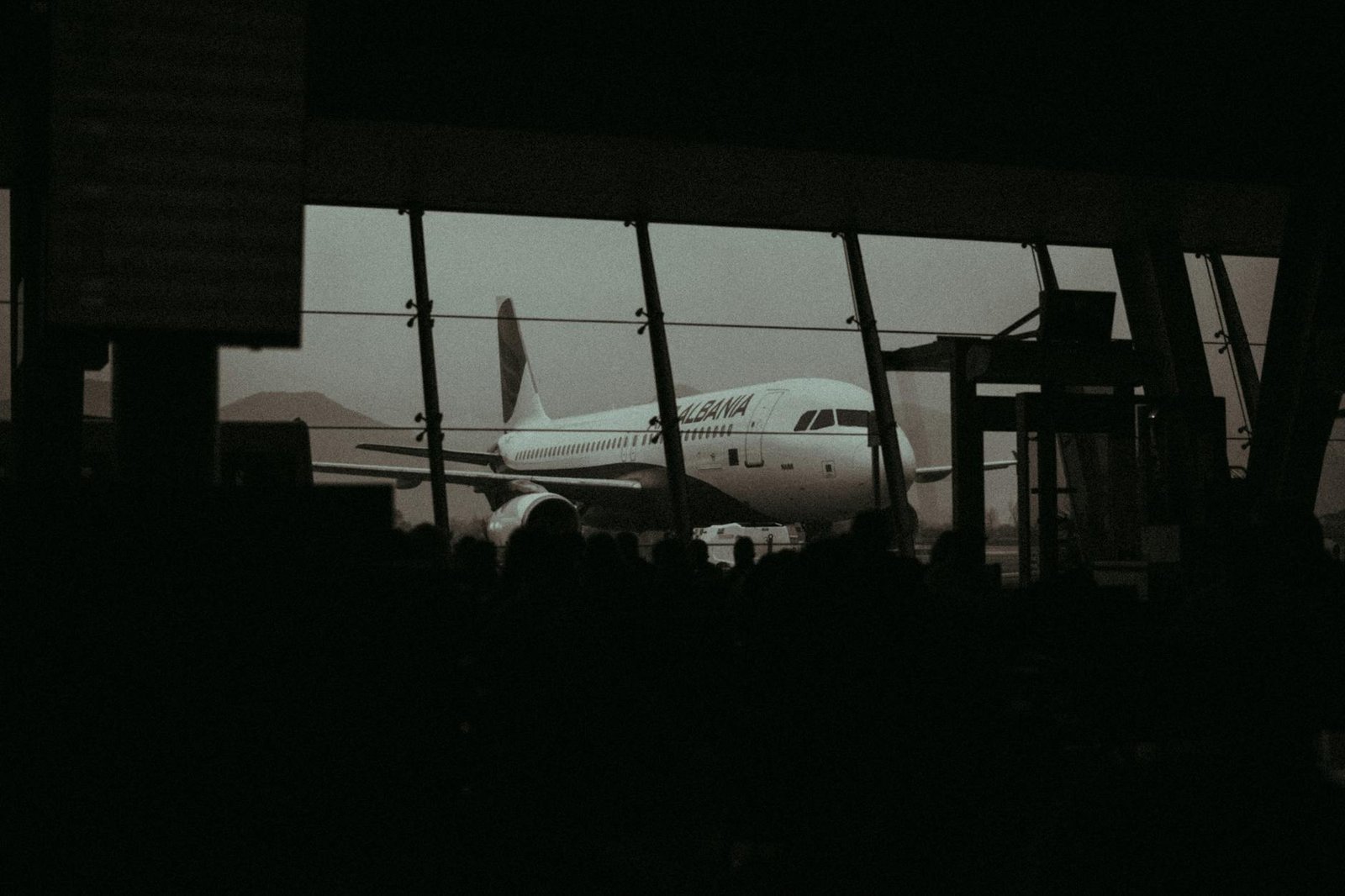 Silhouette d’un avion et de voyageurs dans un terminal d’aéroport pour illustrer la réservation d’un vol long-courrier