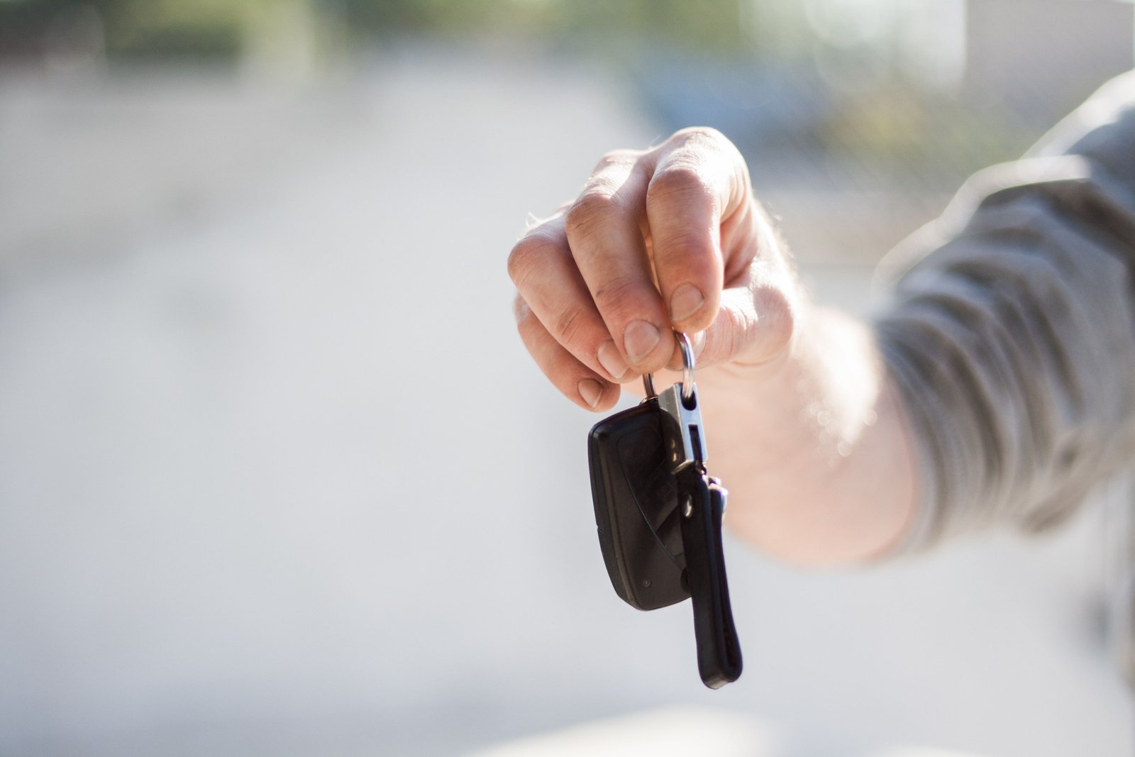 Main remettant des clés de voiture pour illustrer la prise en charge d’une location à l’étranger