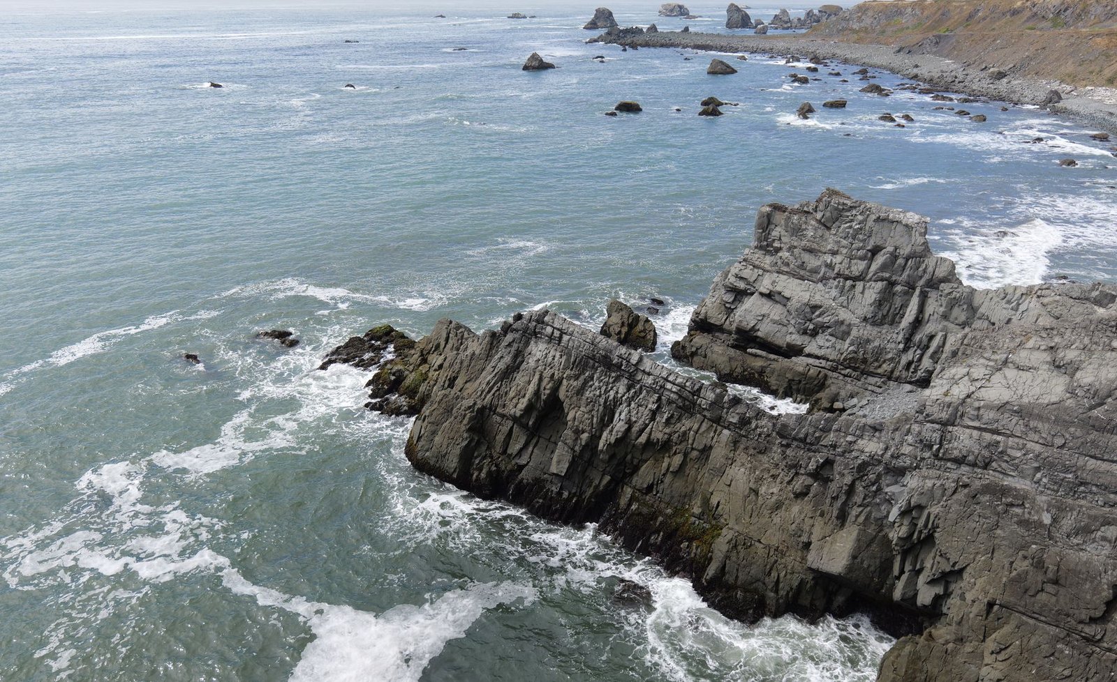 Côte rocheuse battue par les vagues pour évoquer le littoral sauvage de l’Étang-Salé