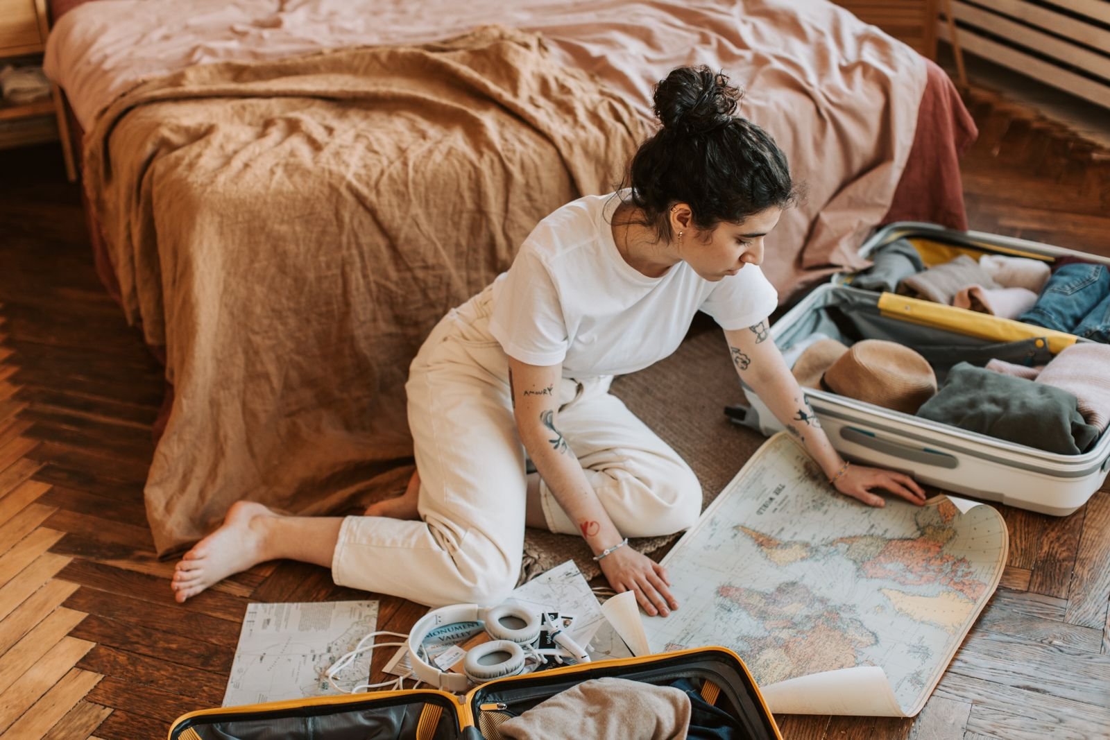 Voyageuse préparant son itinéraire et son hébergement sur une carte