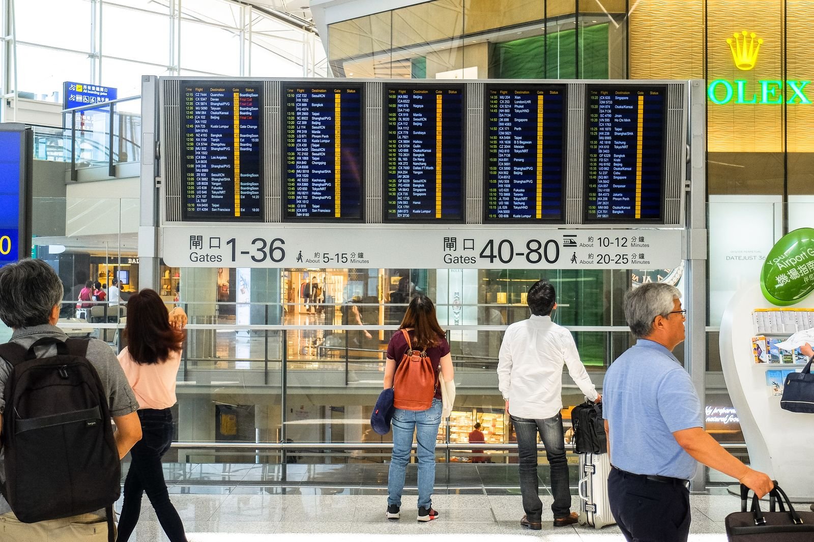 Voyageurs consultant un tableau des départs à l’aéroport